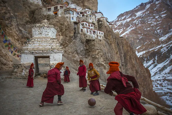 Young Monks Playing Football By Andrew Newey