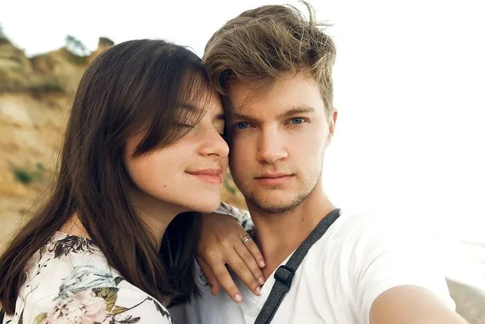 Young couple posing for a selfie outdoors, capturing a moment of trust and friendship before betrayal shocked them.