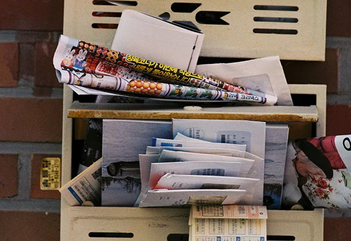 Mailbox overflowing with various letters and flyers, illustrating harmless but effective revenge on jerks through playful tactics.