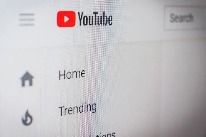 Close-up of YouTube homepage screen showing navigation menu, highlighting trends from 1960 to 2010 birth years.