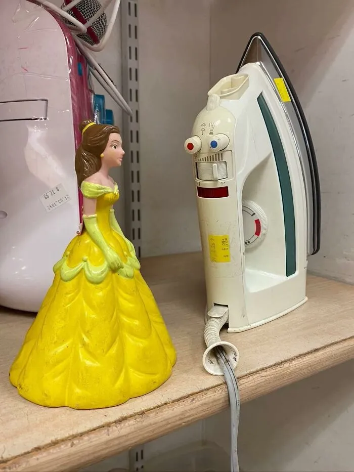 Toy princess figurine facing an iron with pareidolia effect making the iron look like a face with eyes and mouth.