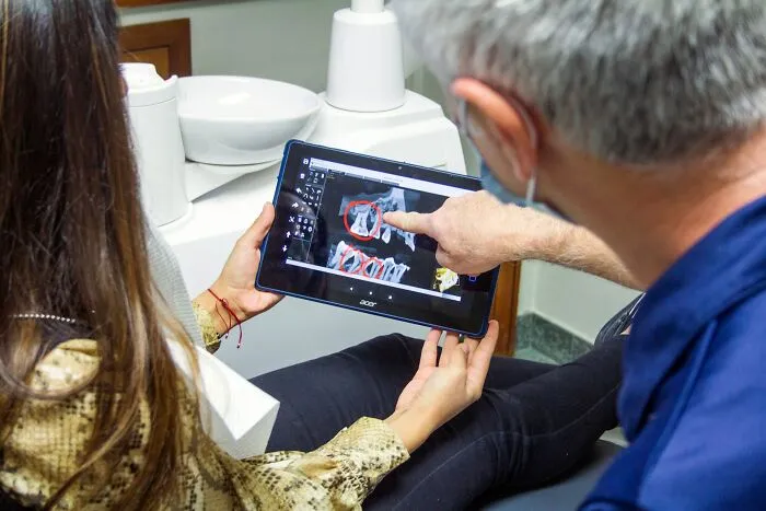 Dentist and patient reviewing dental x-rays on a tablet, highlighting unusual real cases that still feel fake.