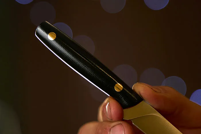 Close-up of a hand holding a sharp knife handle, illustrating key safety tips everyone should know for safe handling.