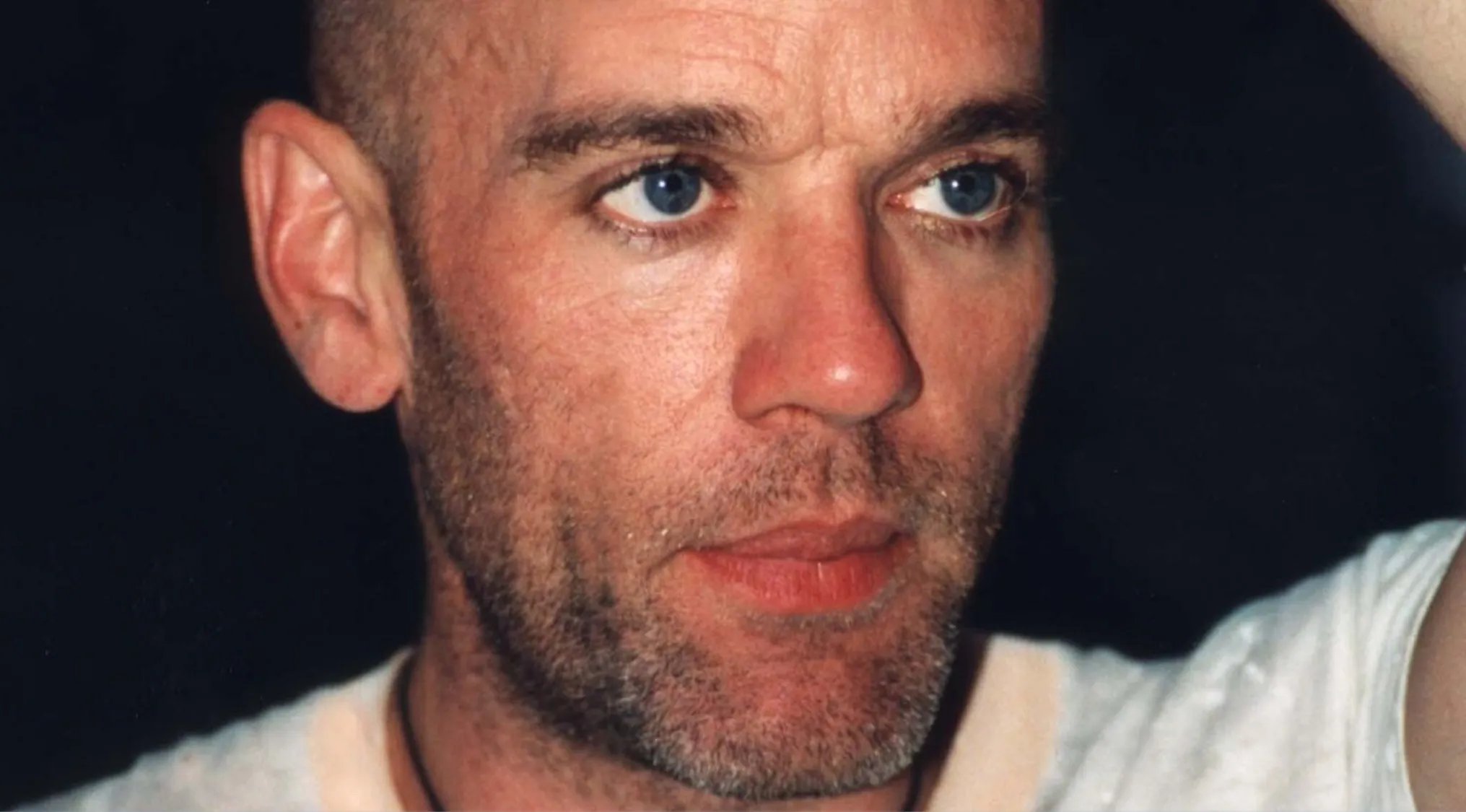 Michael Stipe, lead singer, close up portrait with a shaved head and beard, gazing off-camera. Music Challenge.