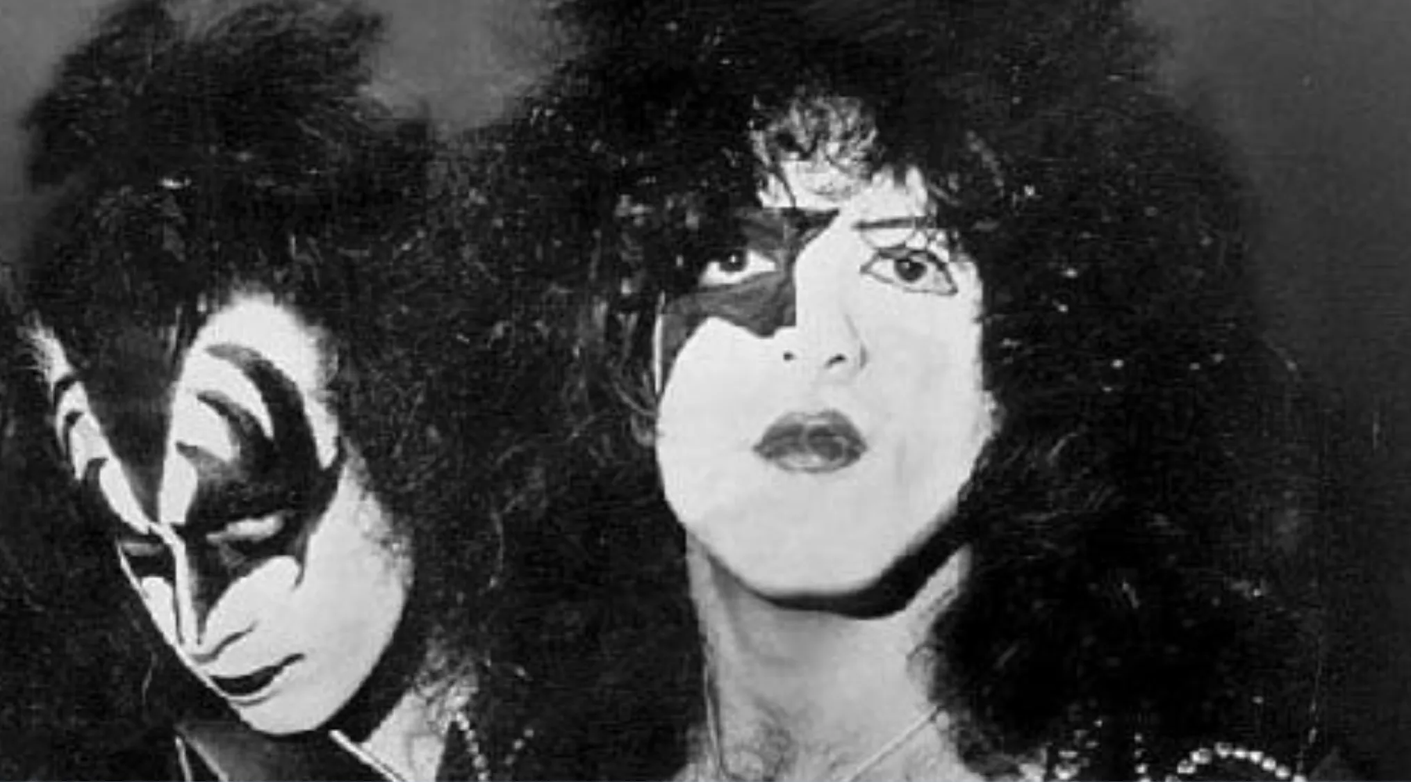 Two members of Kiss, in black and white, wearing their iconic makeup. A music challenge featuring lead singers.