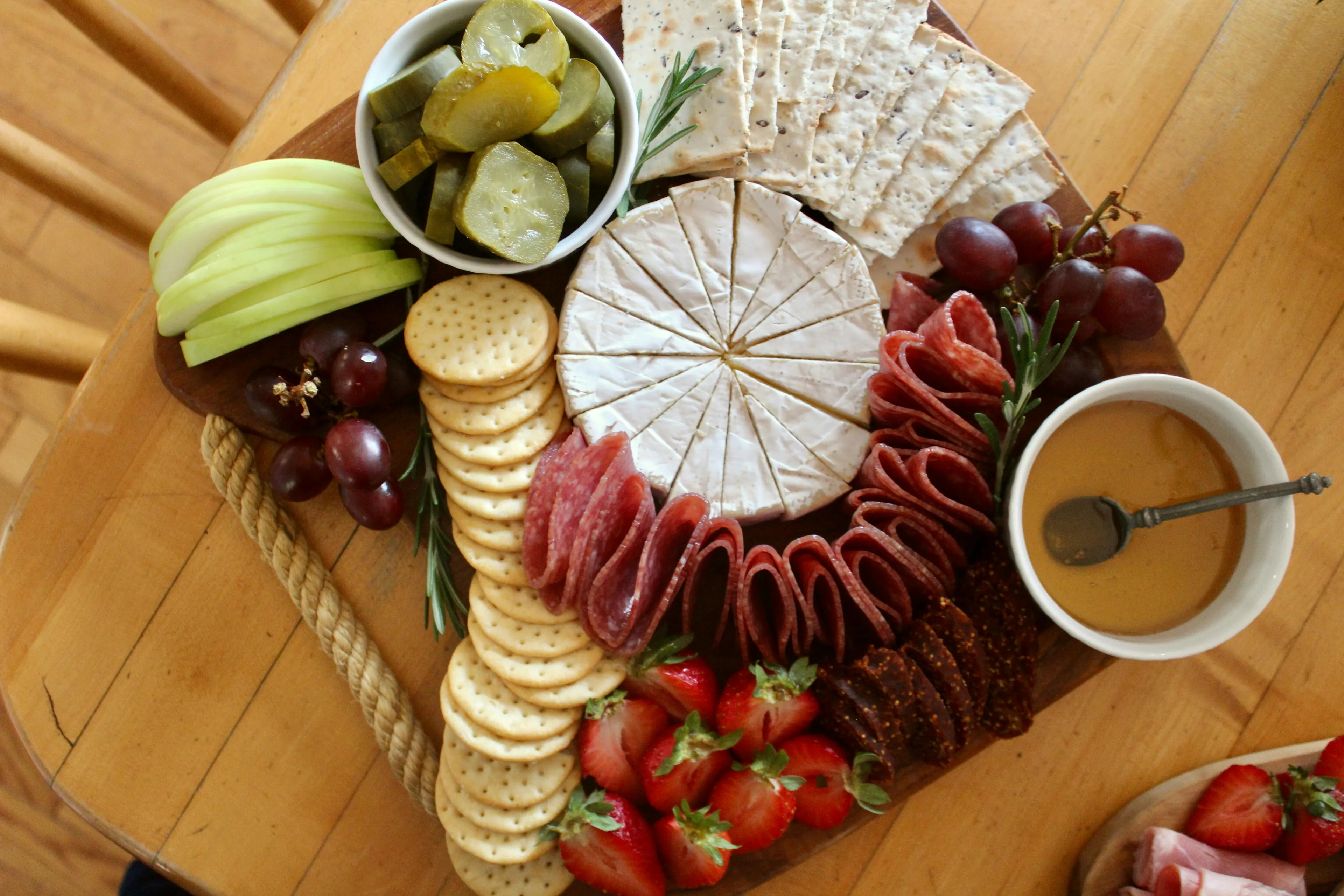 A beautiful charcuterie board filled with cheese, meats, fruits, crackers, and pickles, perfect as a late-night snack.