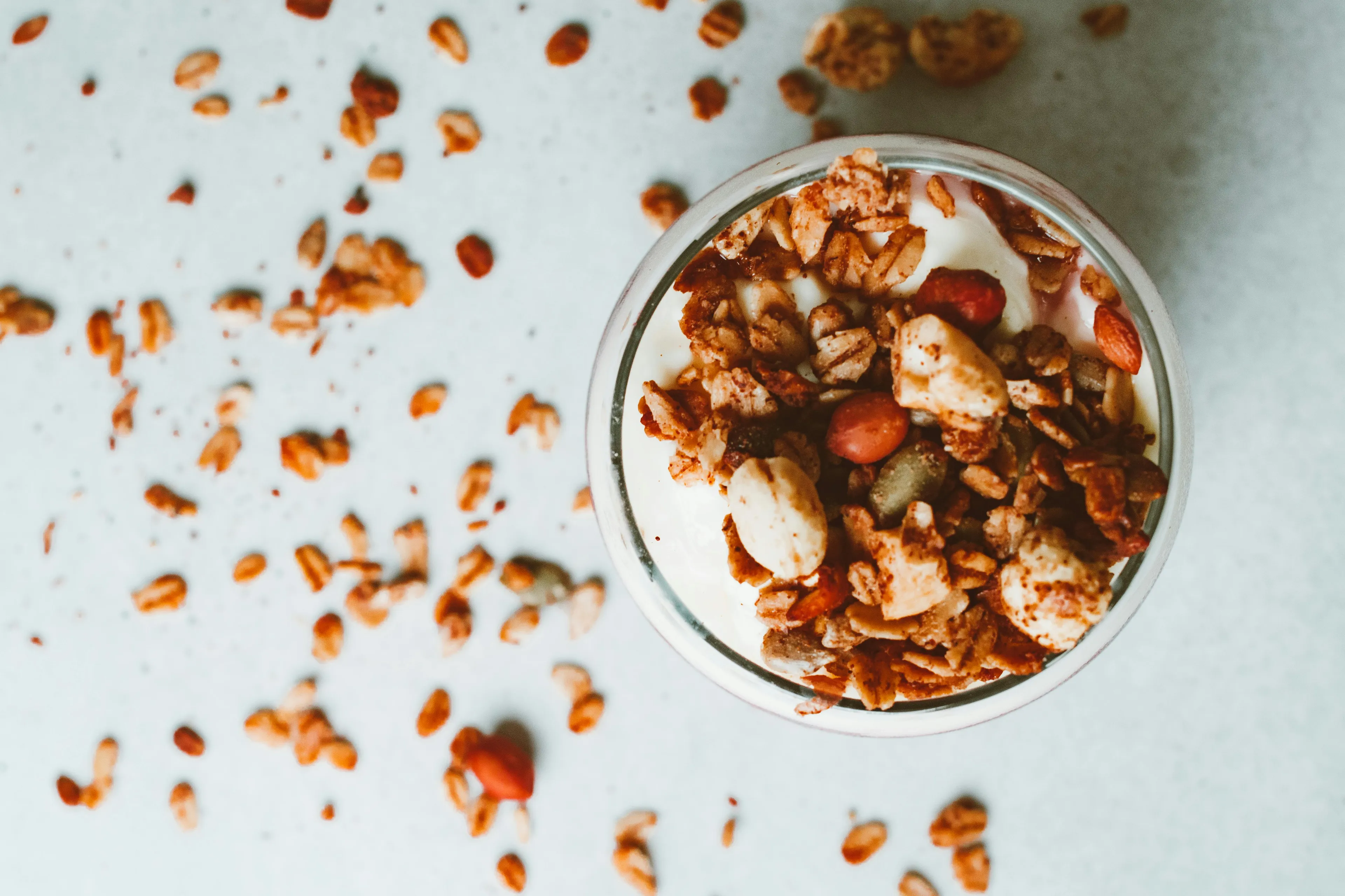 Overhead shot of a glass of Greek yogurt with granola, nuts, and berries, for a late-night snack.