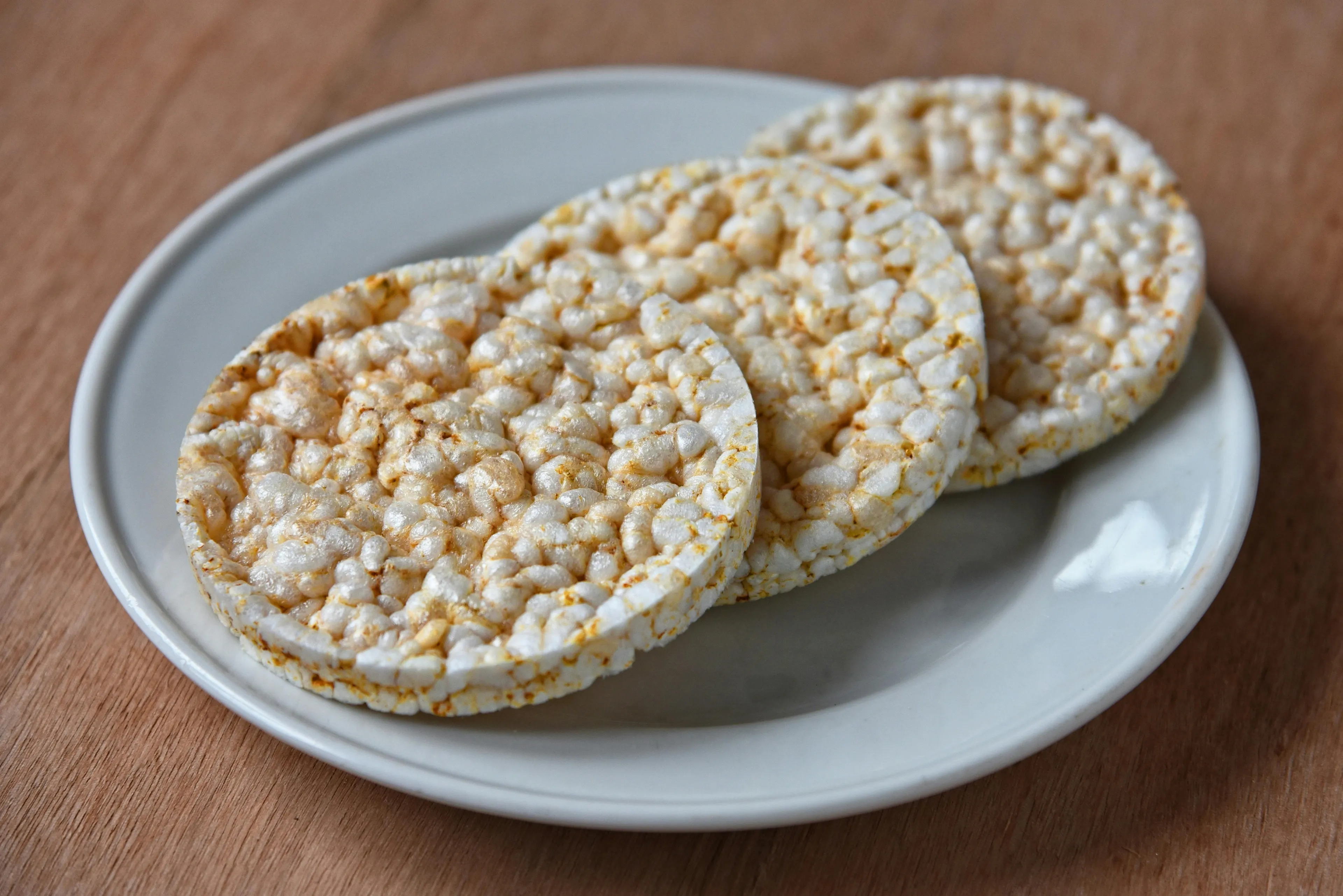 Three round rice cakes on a white plate, perfect for a late-night snack.