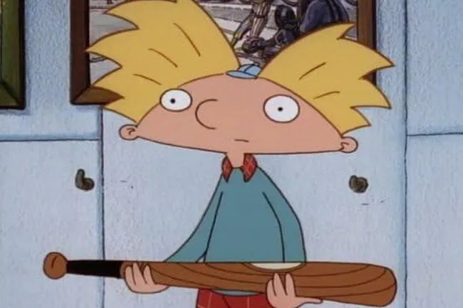 Cartoon character Hey Arnold!, wearing a blue shirt and baseball cap, holding a wooden bat.