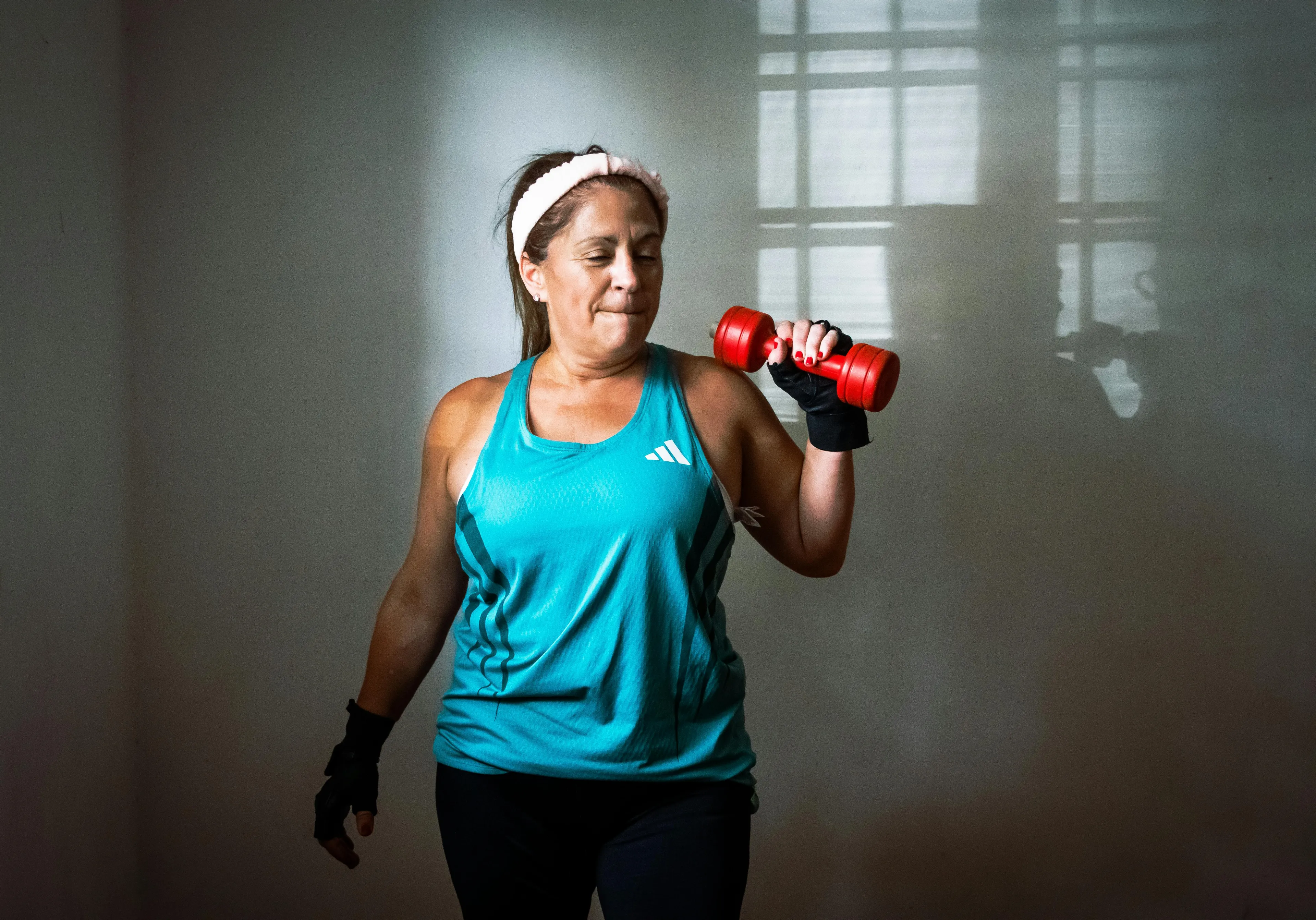 Woman lifting weights, illustrating the self-sabotage pattern of planned workouts vs. actual events.