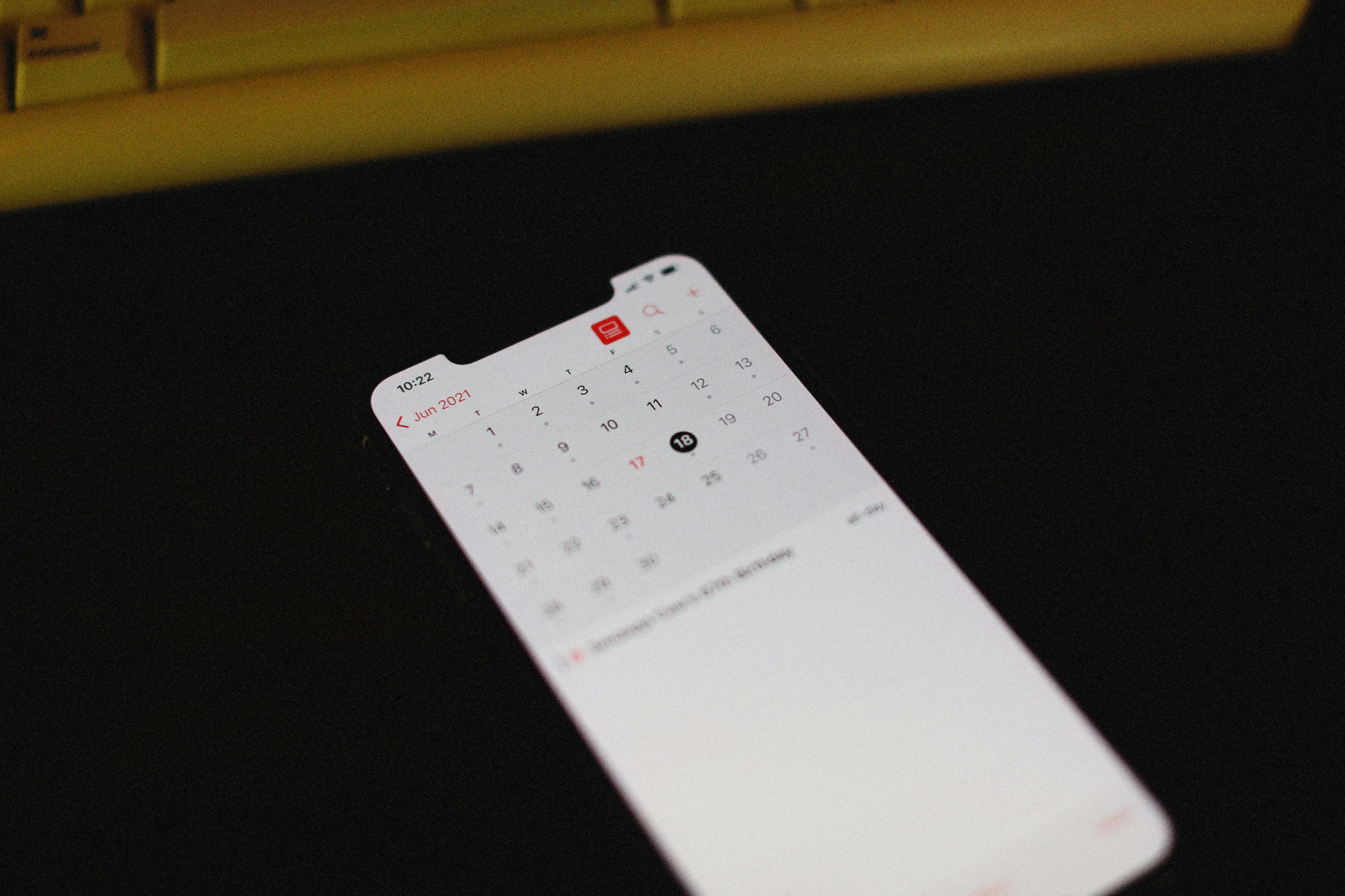 A smartphone displays a calendar with June 2021 visible. This could signify a forgotten dentist appointment and self-sabotage pattern.