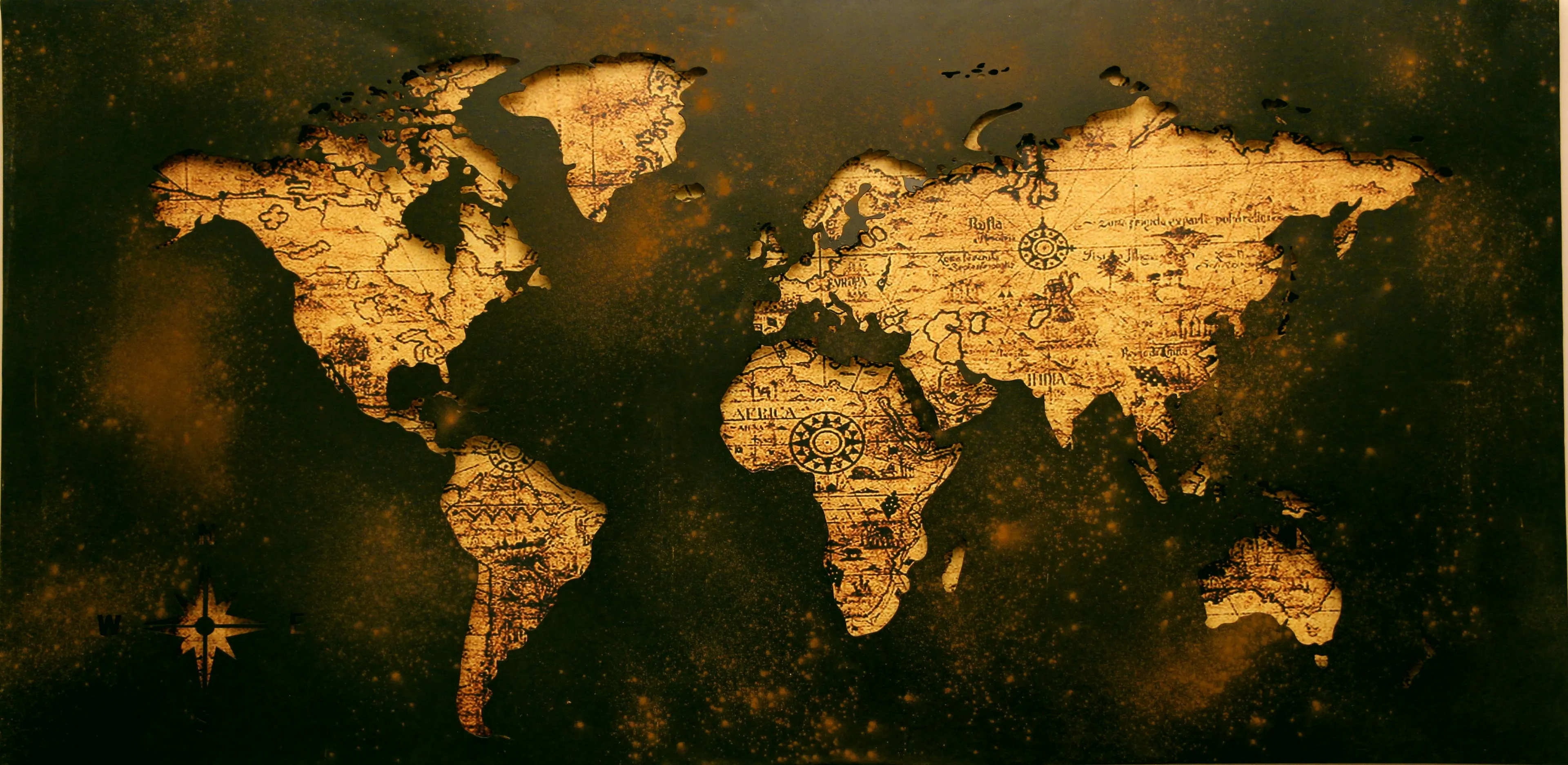 A vintage map of the world with an aged, textured look, perfect as a desktop wallpaper. The continents are golden brown against a dark green sea with faint speckles.
