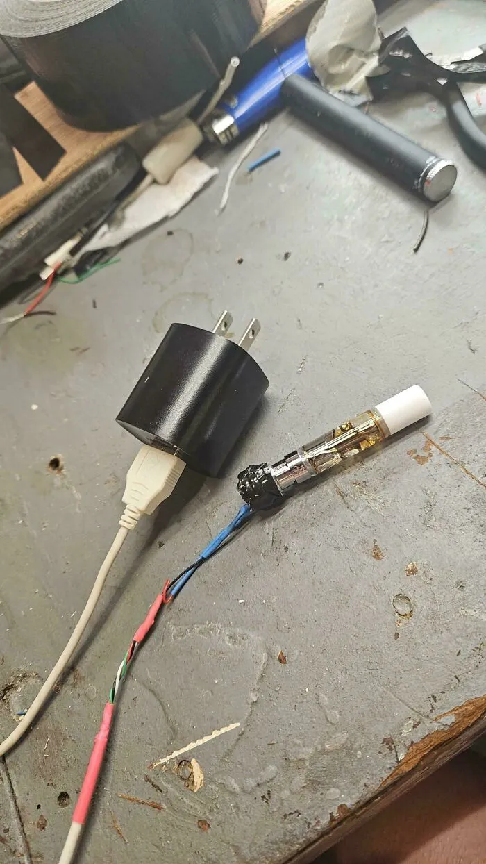 A USB charger with wires connected to a vape cartridge, a clever solution.