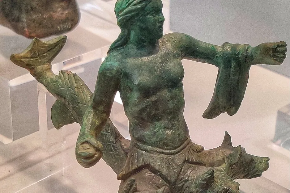 A bronze statue of Scylla, a monster with a female torso, fish tail, and dog-like appendages.