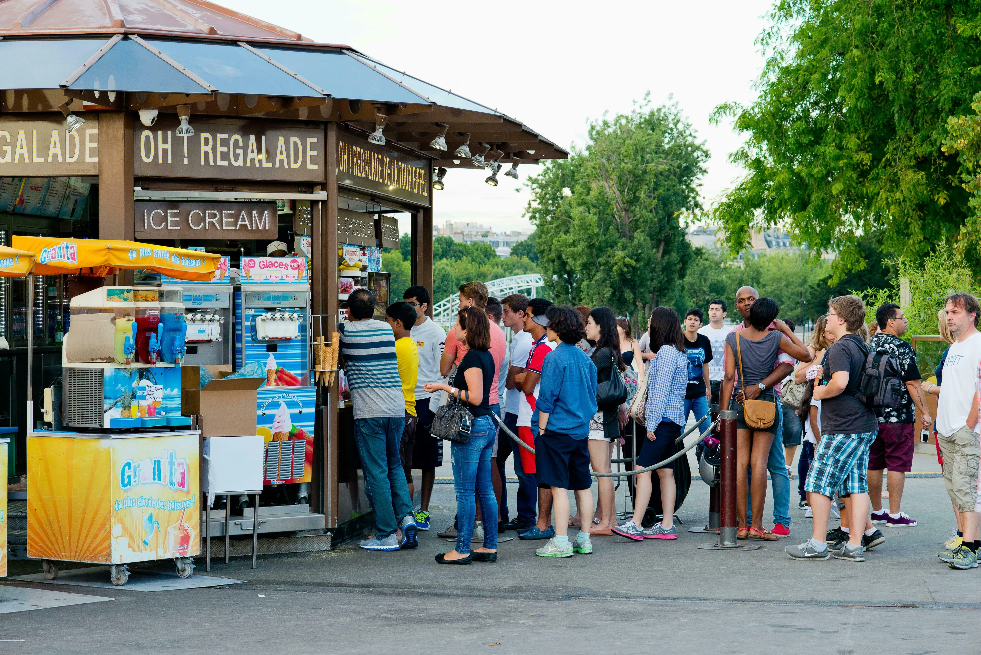 A diverse group of people waiting for ice cream at an outdoor stand, showcasing Great British Vocabulary differences.