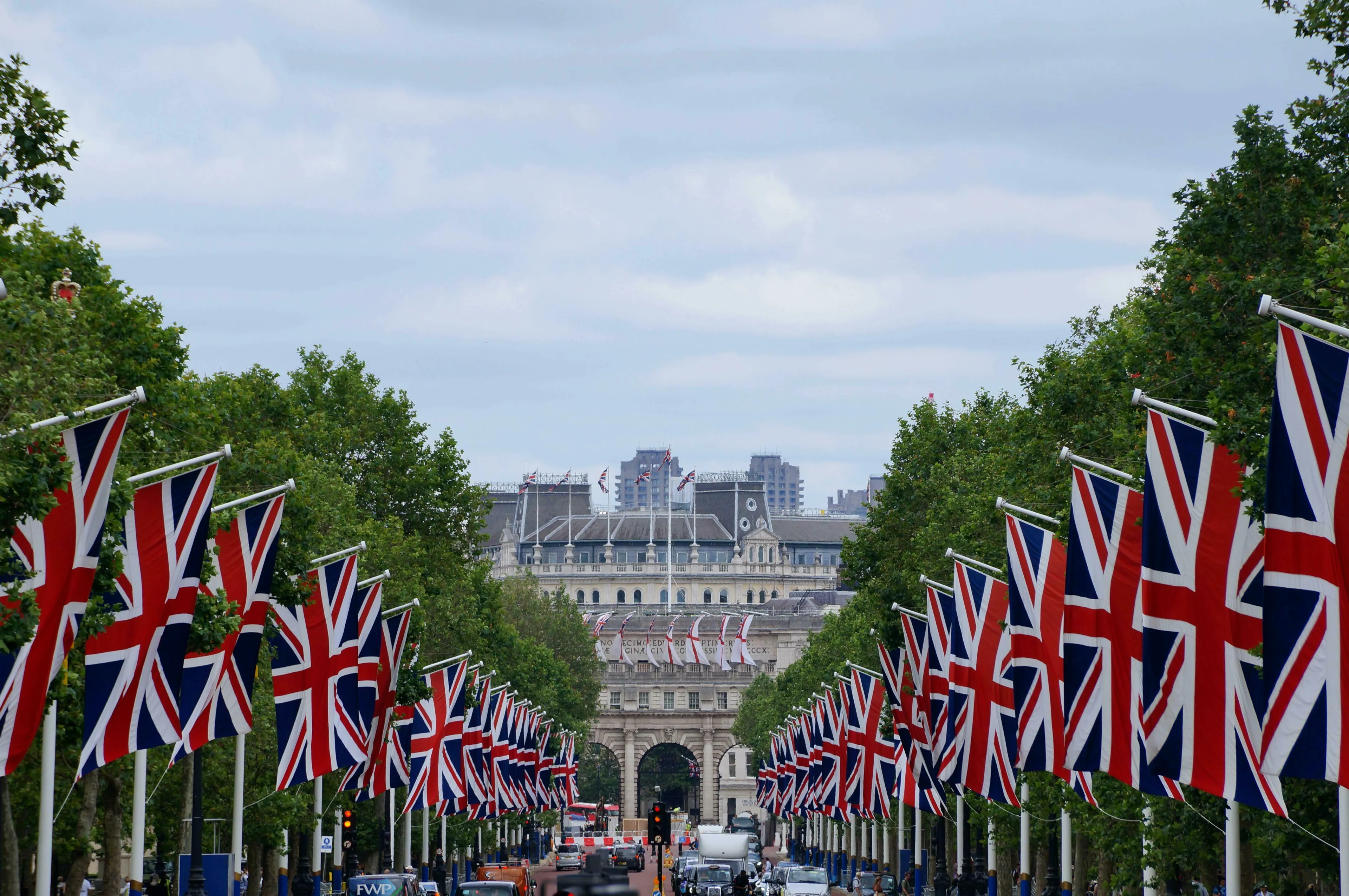 British flags line a tree-lined street leading to a grand building, prompting thoughts on British vocabulary and slang.