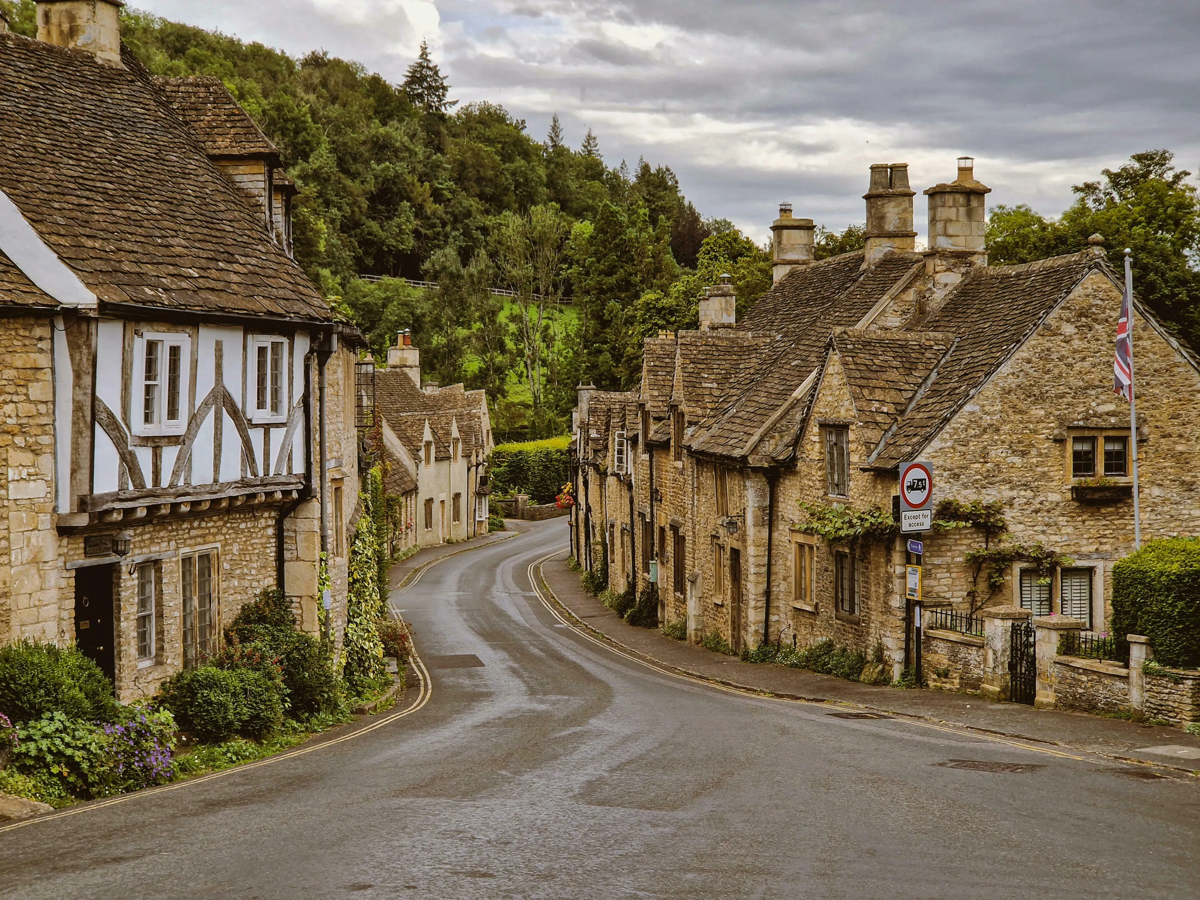 Charming Cotswolds village scene, featuring traditional stone cottages and a winding road, reflecting British vocabulary.