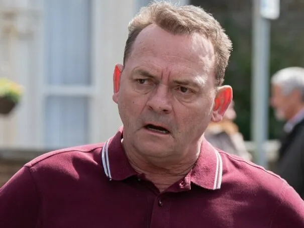 Man in a red polo shirt with a confused expression, ready for a British Vocabulary Quiz.