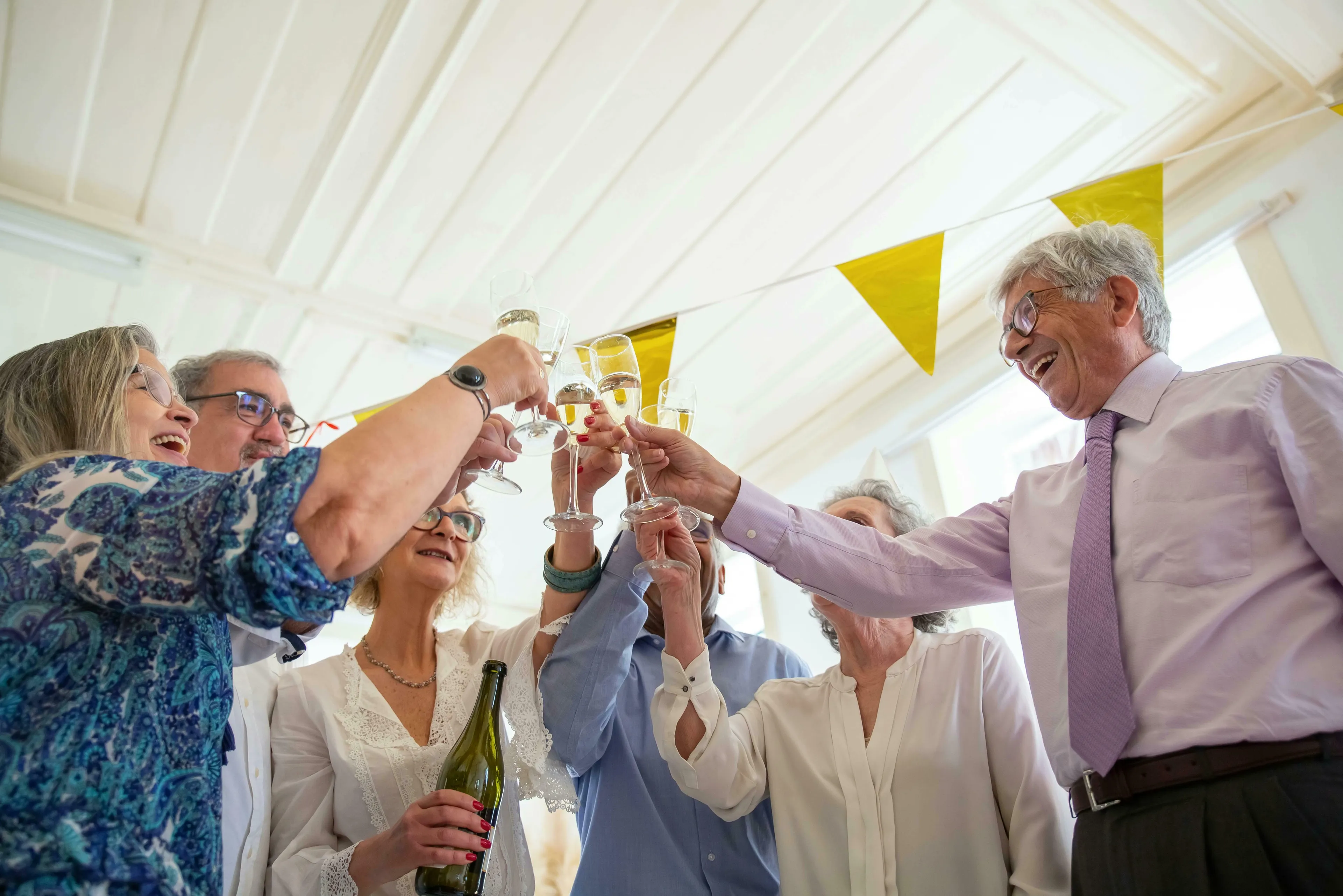 Joyful group of friends toasting with champagne, celebrating with British vocabulary and cheers.
