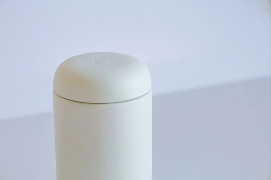 A minimalist pale green cylindrical container with a rounded top, possibly a Deodorant stick, against a white background.