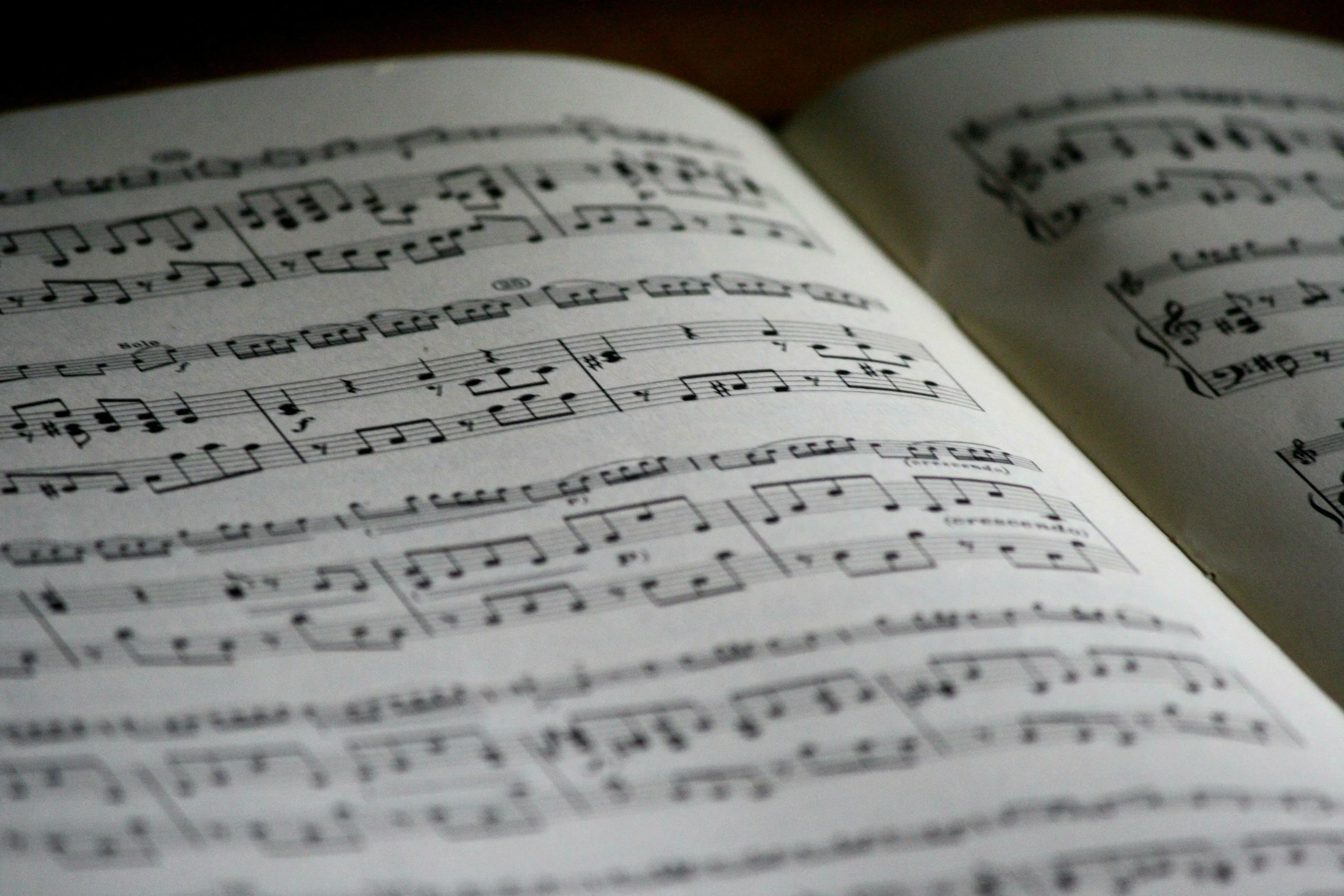 Sheet music open to two pages, black notes and lines on white paper. General knowledge quiz for high IQs.