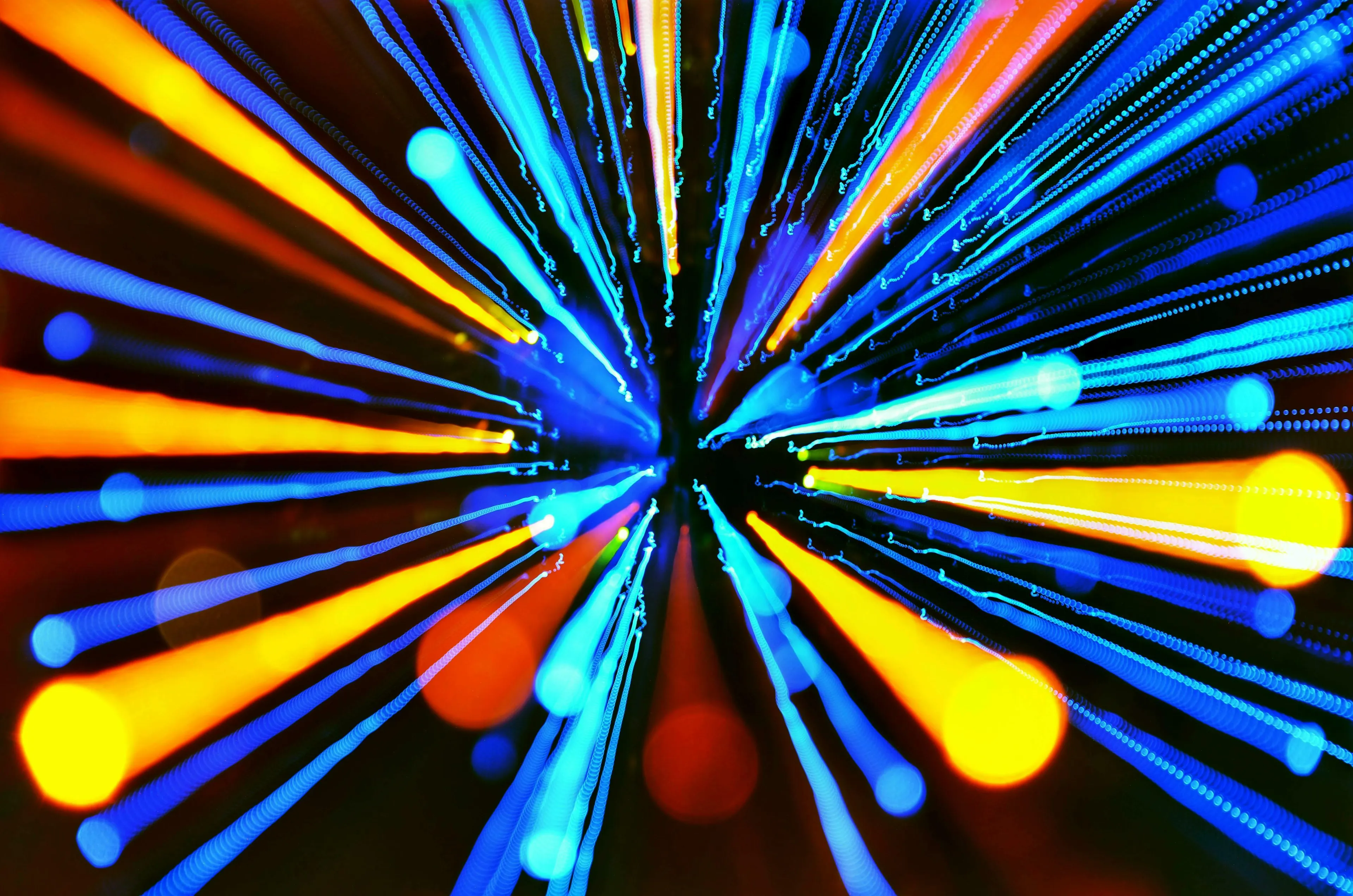 Abstract blur of blue and orange light streaks converging at the center, representing the speed of light in a vacuum for a difficult general knowledge quiz.