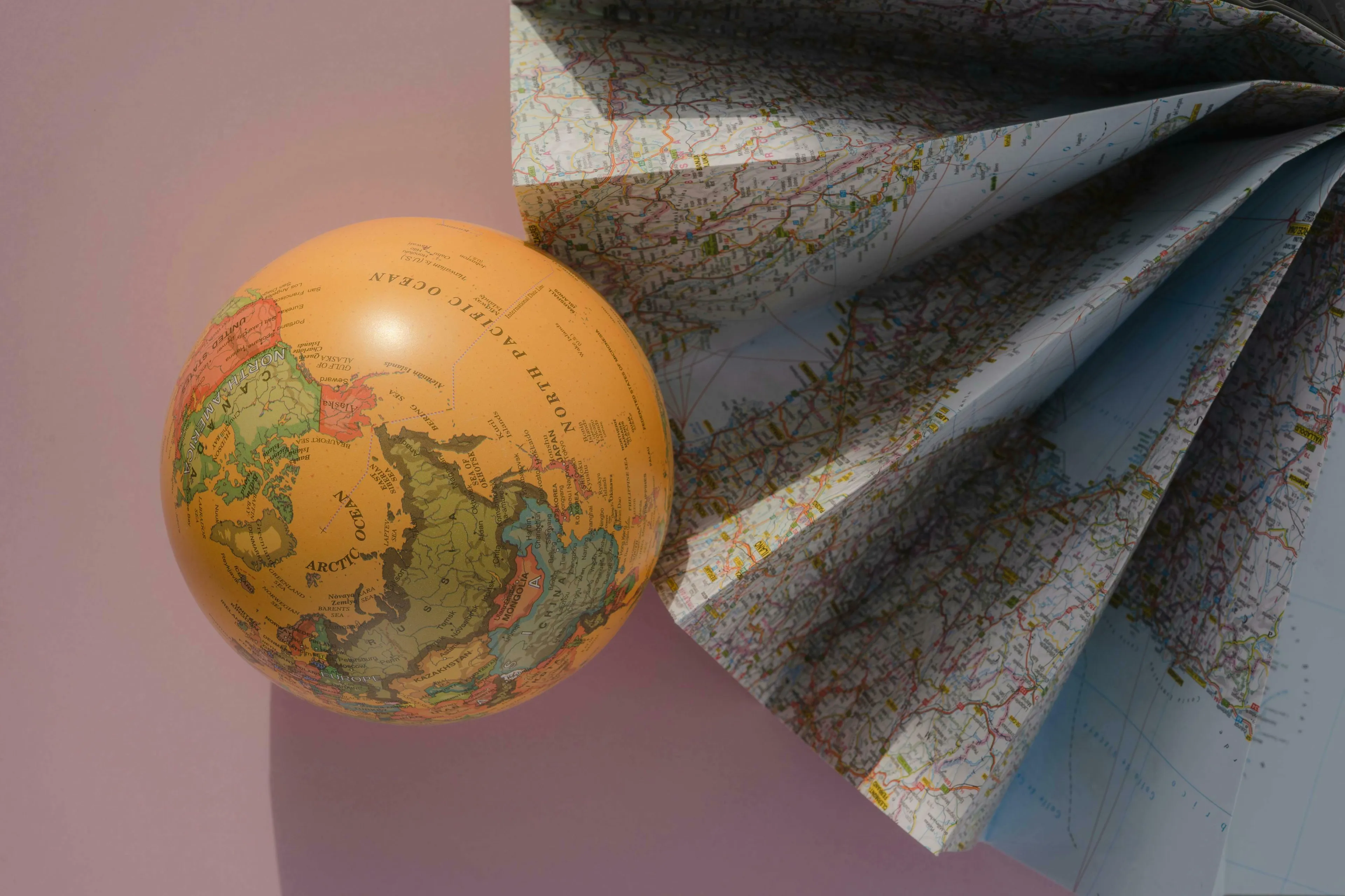 A globe and a folded map. Test your general knowledge and high IQ.