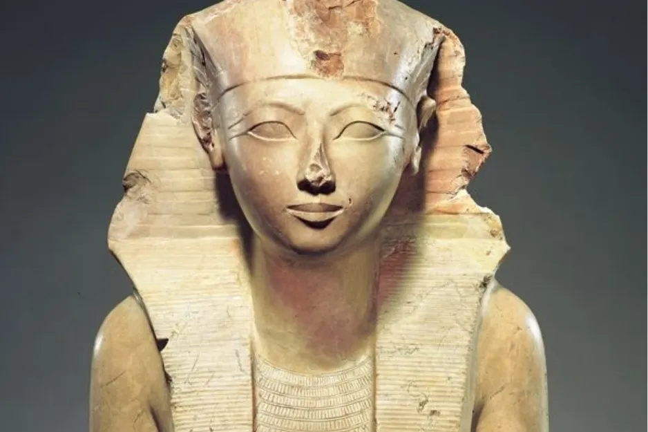 Close-up of Hatshepsut statue, showing a pharaoh in nemes headdress, with delicate facial features and a serene expression.