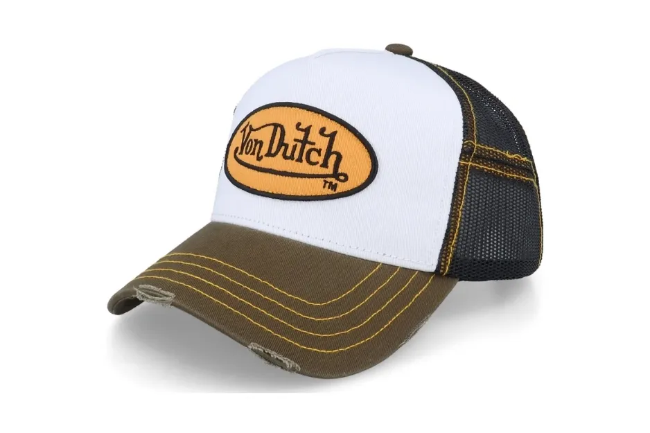 Von Dutch trucker hat, a popular 00s Y2K trend accessory. White front, olive brim, black mesh back, and orange logo.