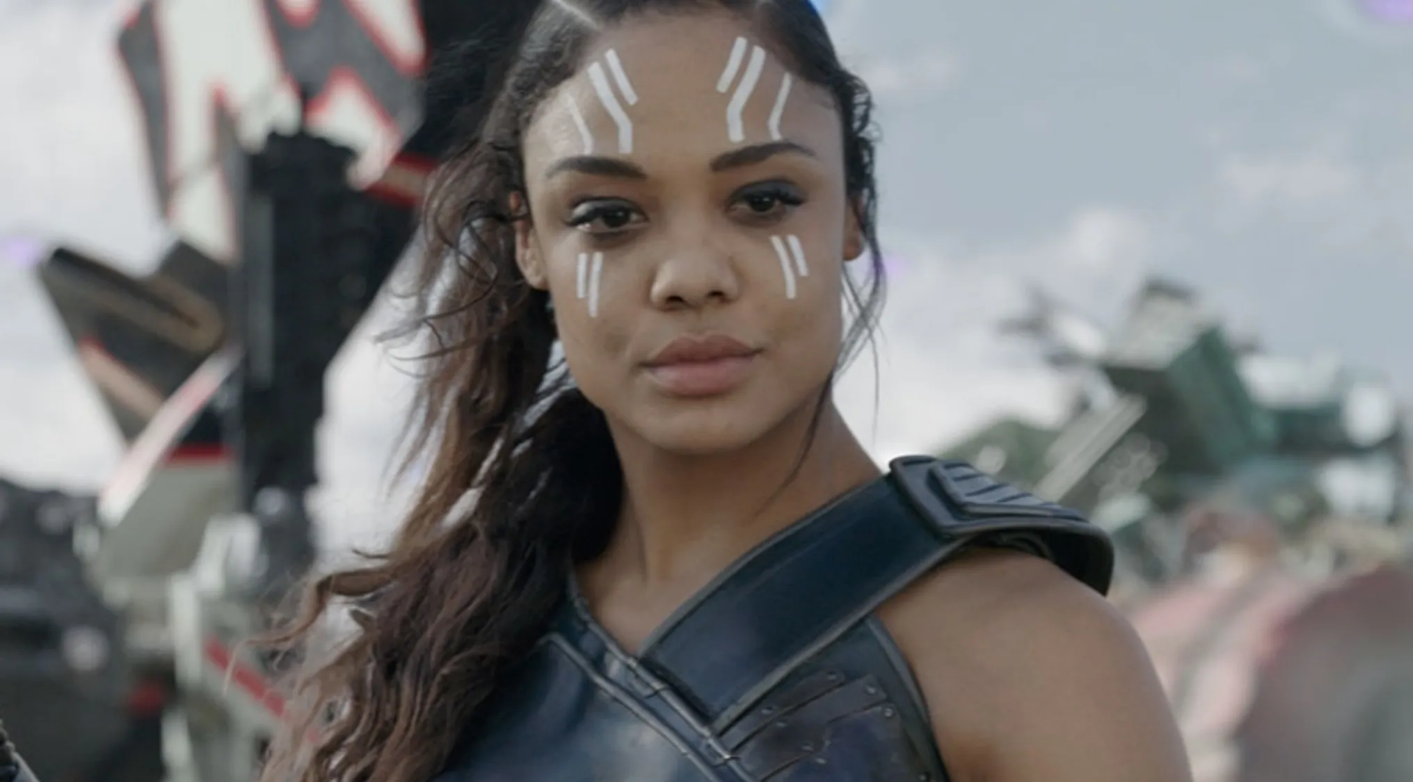 Close-up of a celebrity name, Tessa Thompson, with white face markings, wearing armor. How well can you spell celebrity names?