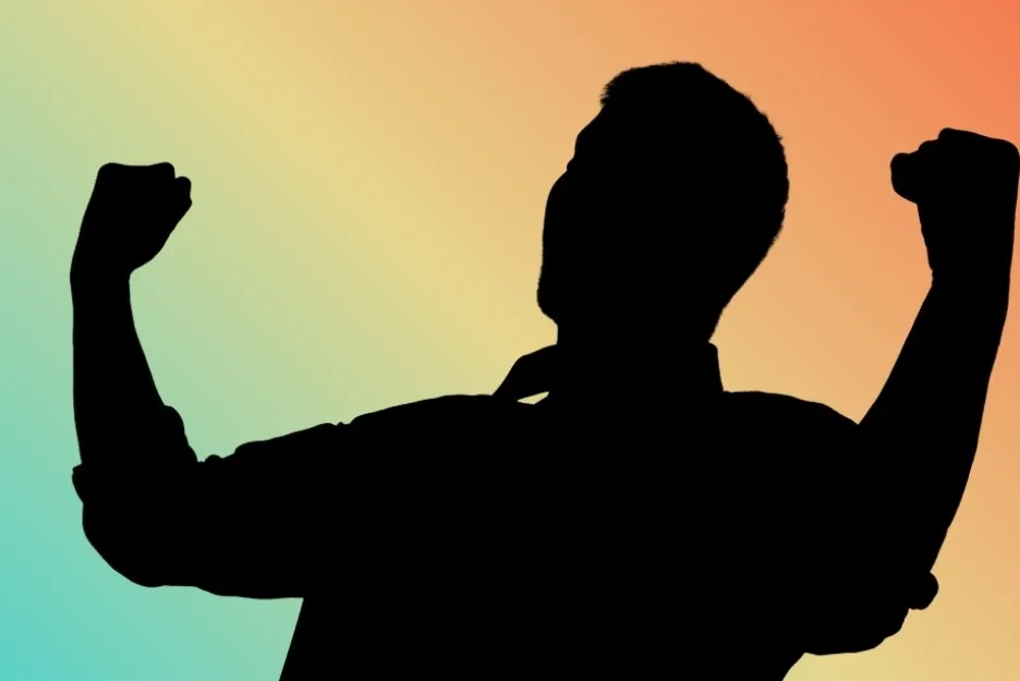A dark silhouette of a man flexing both biceps against a vibrant, multi-colored background. Could this be Rocky?