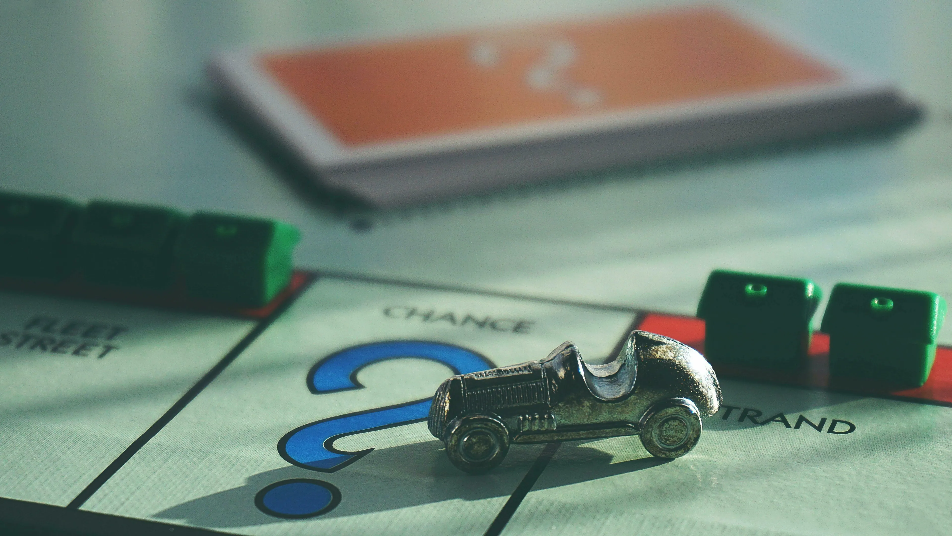 A close-up of a Monopoly board game, with the car token on a Chance square. Real Or Fake Trivia.