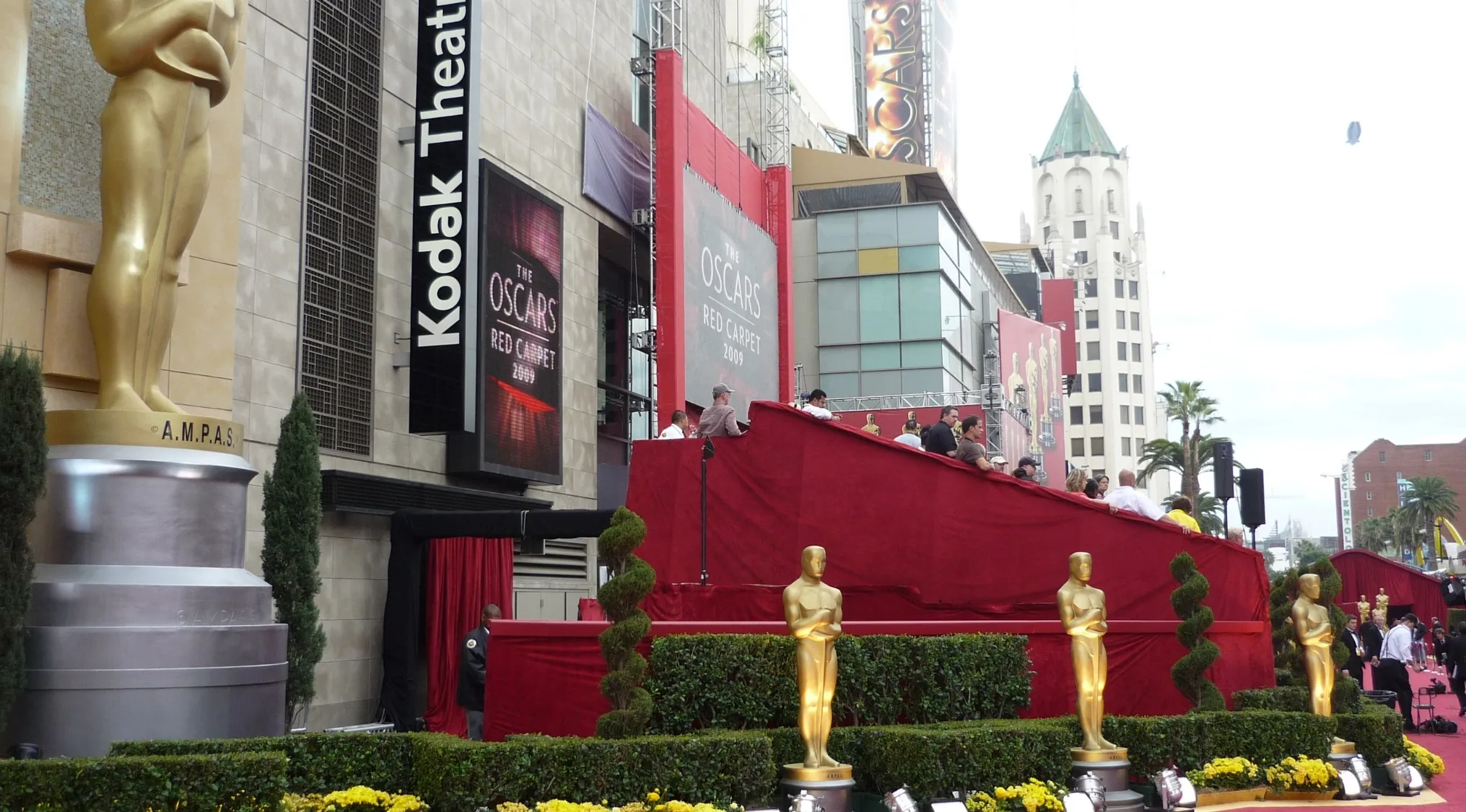 Real Or Fake Trivia: Large Oscar statues adorn a red carpet event outside the Kodak Theatre, ready for celebrities.