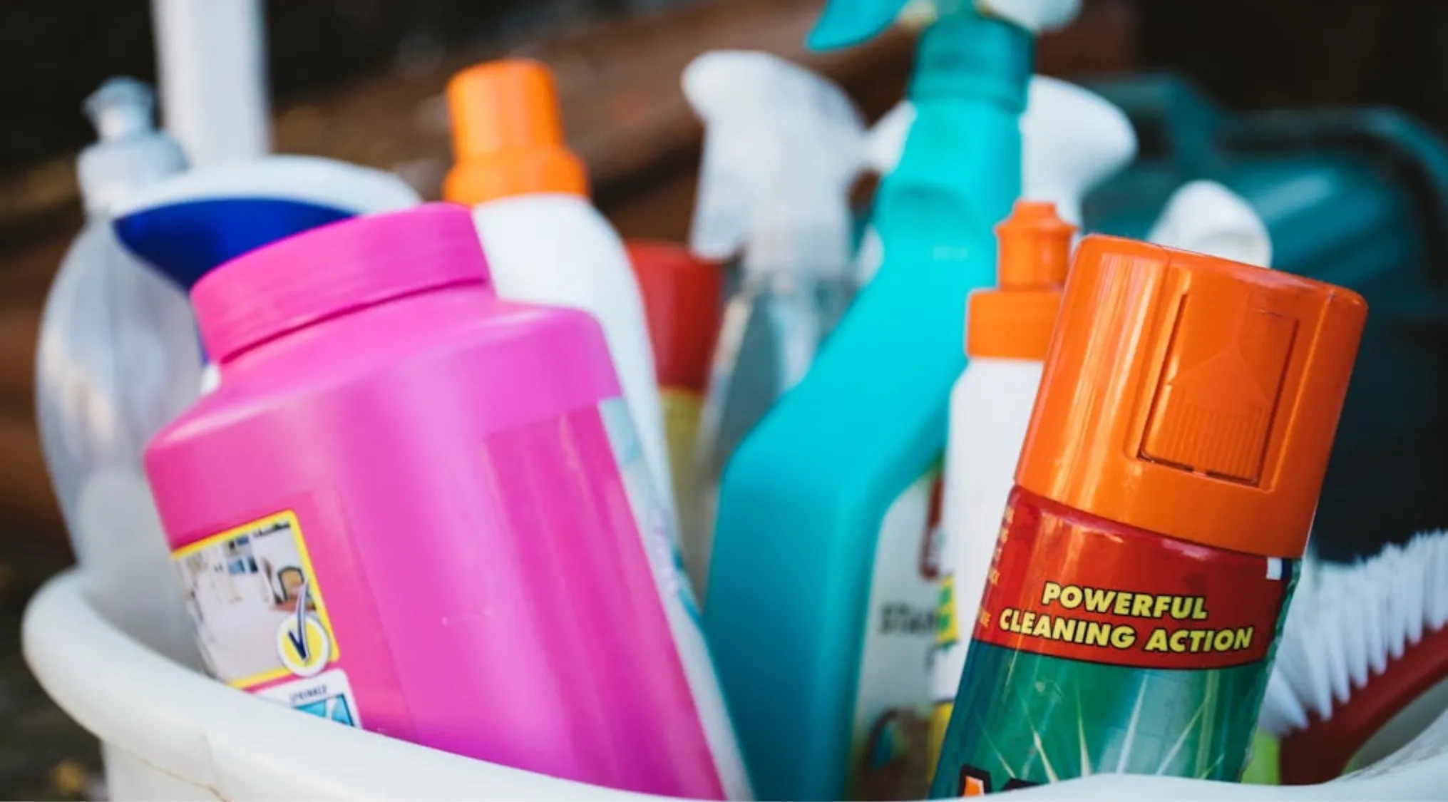 A collection of colorful cleaning products, including spray bottles and detergents, useful for Home Economics cleaning tips.