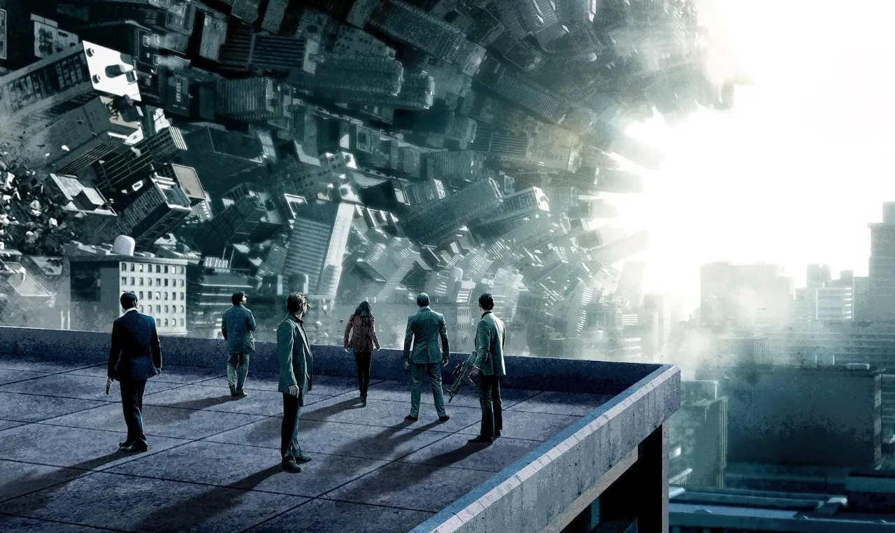 Inception film still: A group of people stand on a rooftop, gazing at a cityscape that is folding inwards.