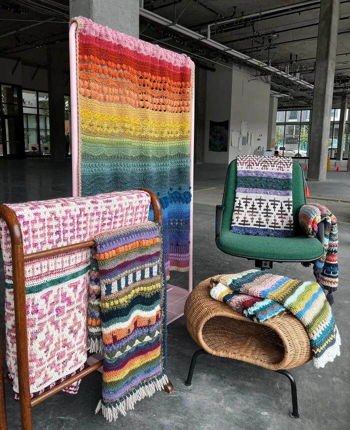 Colorful crocheted blankets and throws displayed on furniture indoors