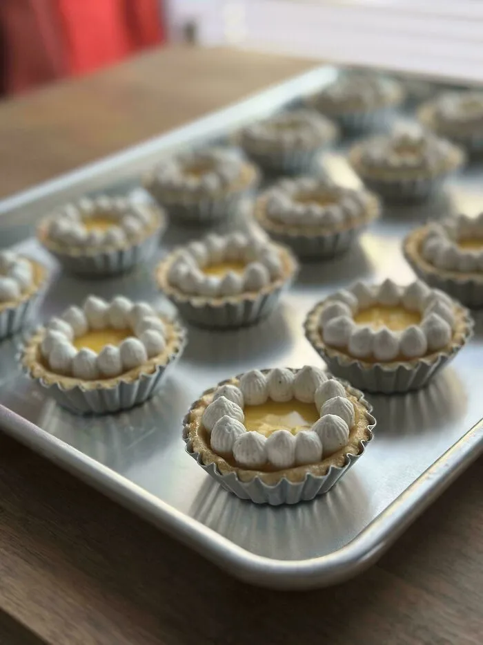 Mini tarts with cream topping on a baking tray dessert