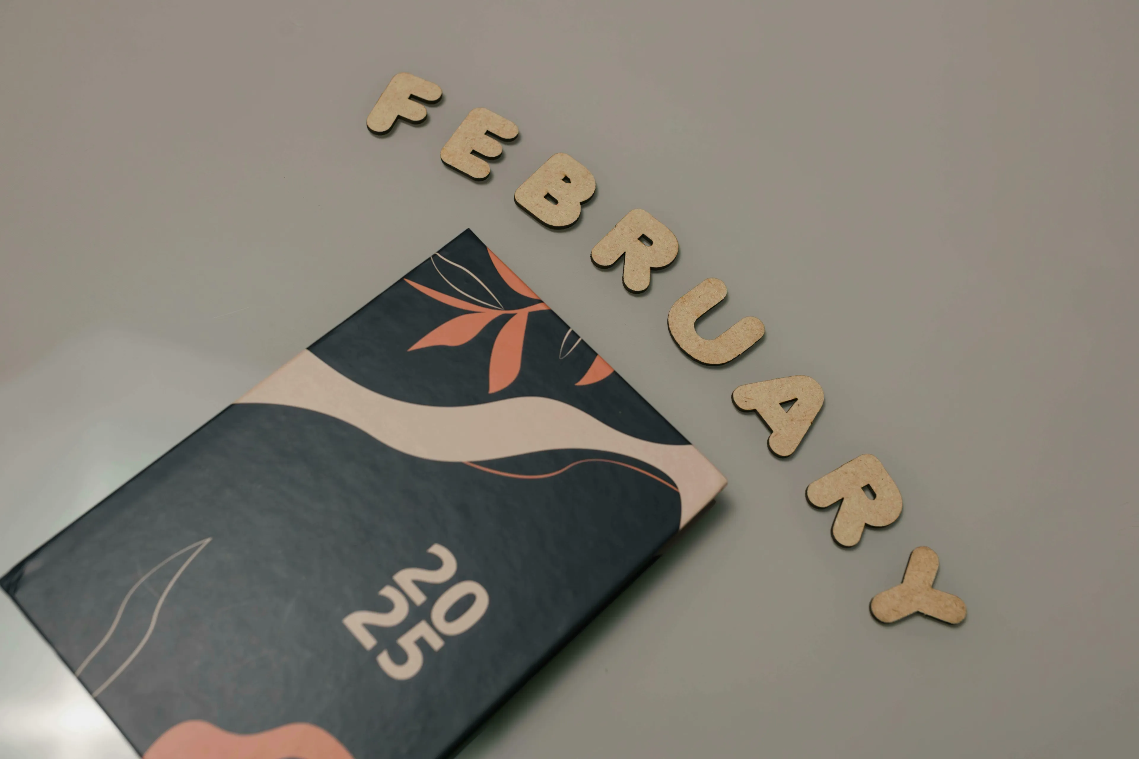 Wooden letters spelling "February" with a notebook reading "2025," illustrating a Who Wants To Be A Millionaire? question about leap year days in February.