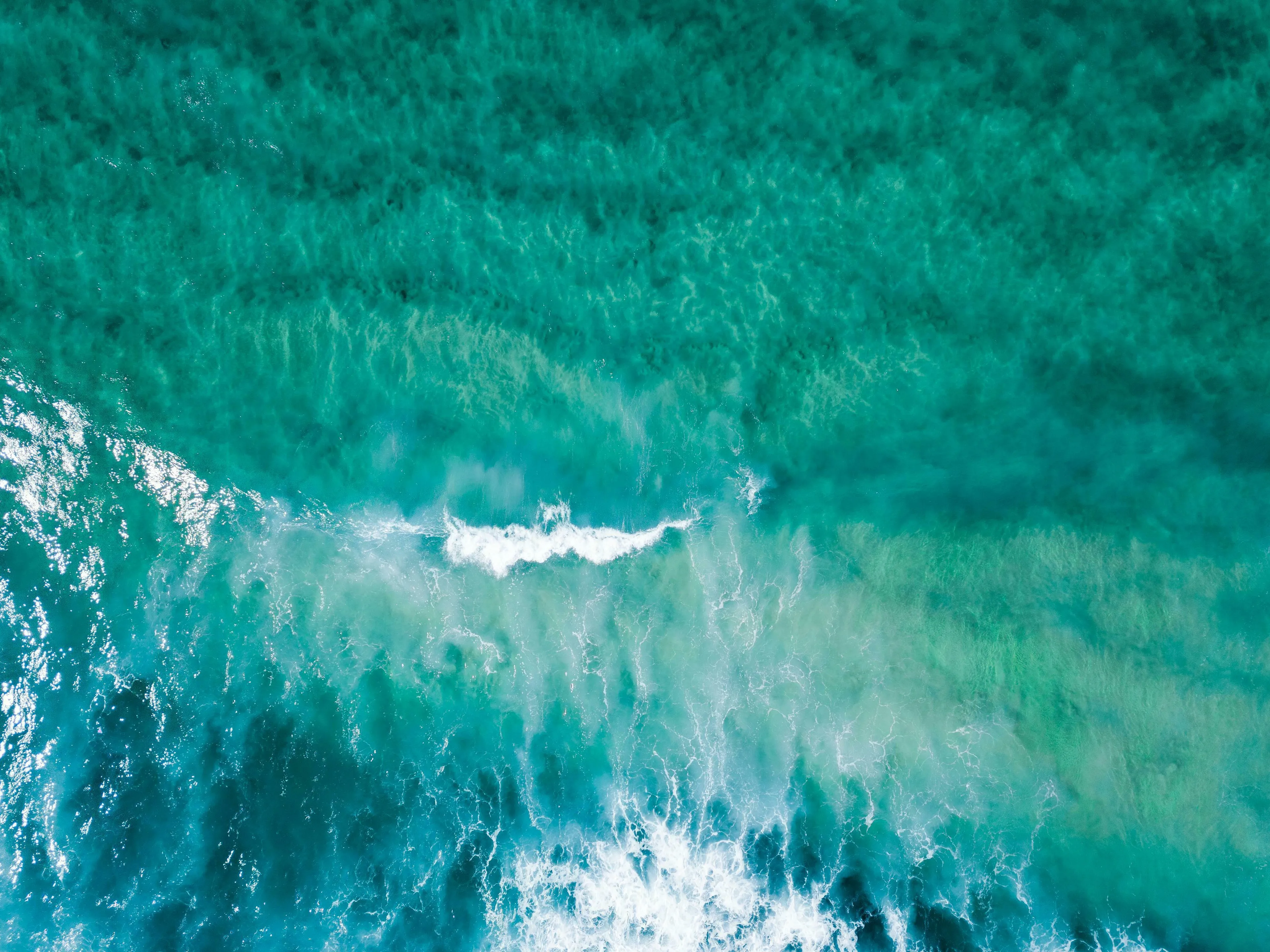 Aerial view of vibrant turquoise ocean waves, a stunning visual for Who Wants To Be A Millionaire questions about oceans.