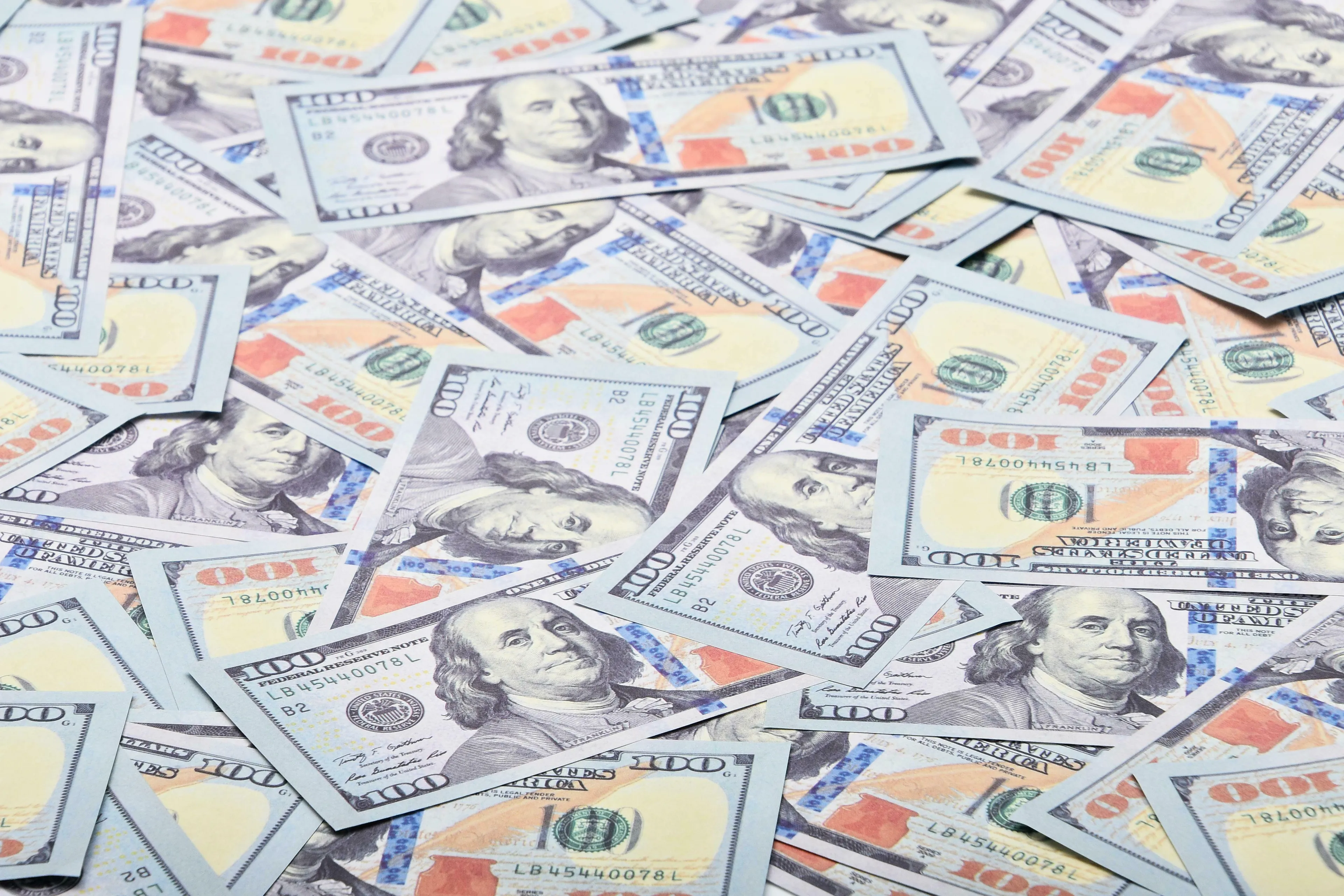 A scattered pile of US hundred-dollar bills. Money is everywhere, hinting at the Who Wants To Be A Millionaire game and the number of zeros in one million.