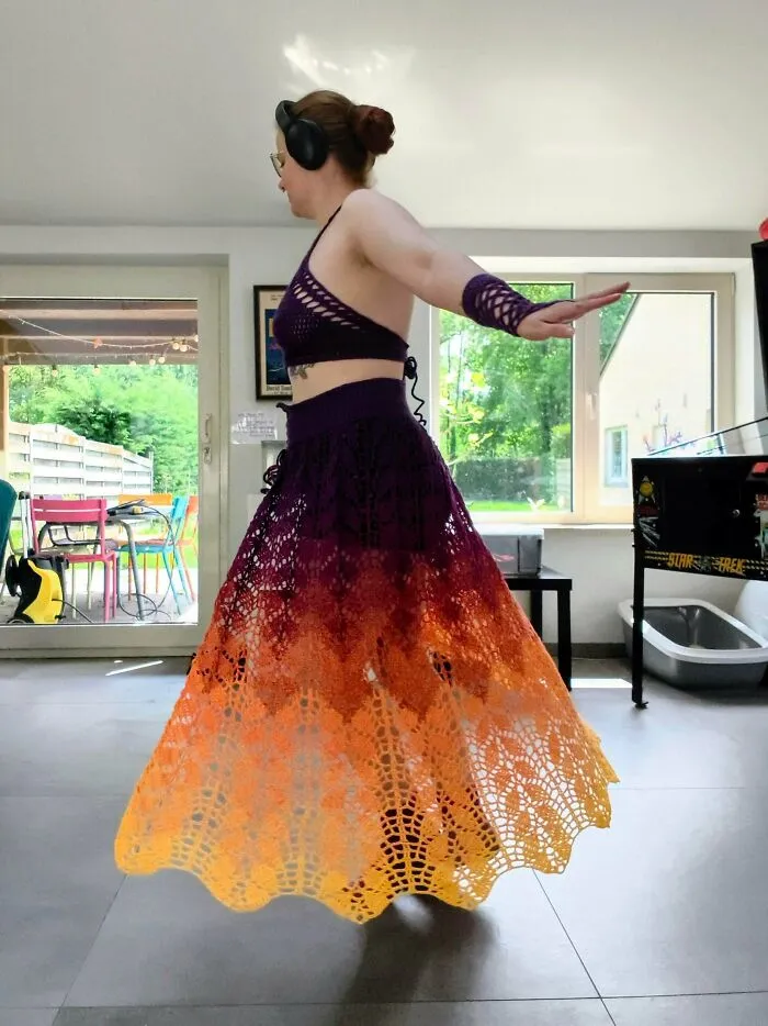 Person wearing crochet top and skirt set in gradient colors spinning indoors