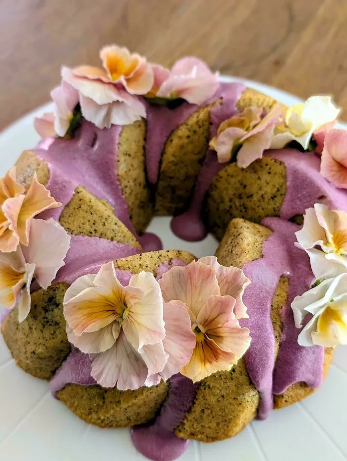 Bundt cake with purple frosting and pansy flower decorations