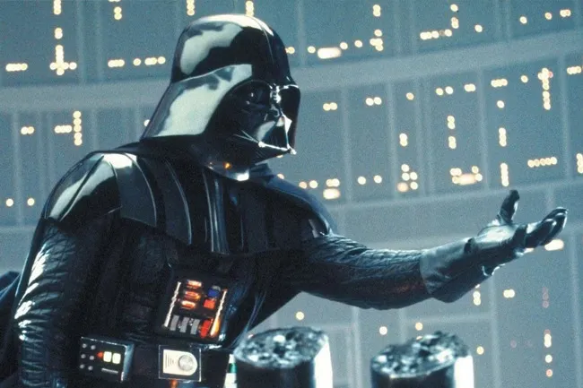 Darth Vader in his iconic black suit and helmet, with his right hand extended, in a futuristic, dimly lit setting.
