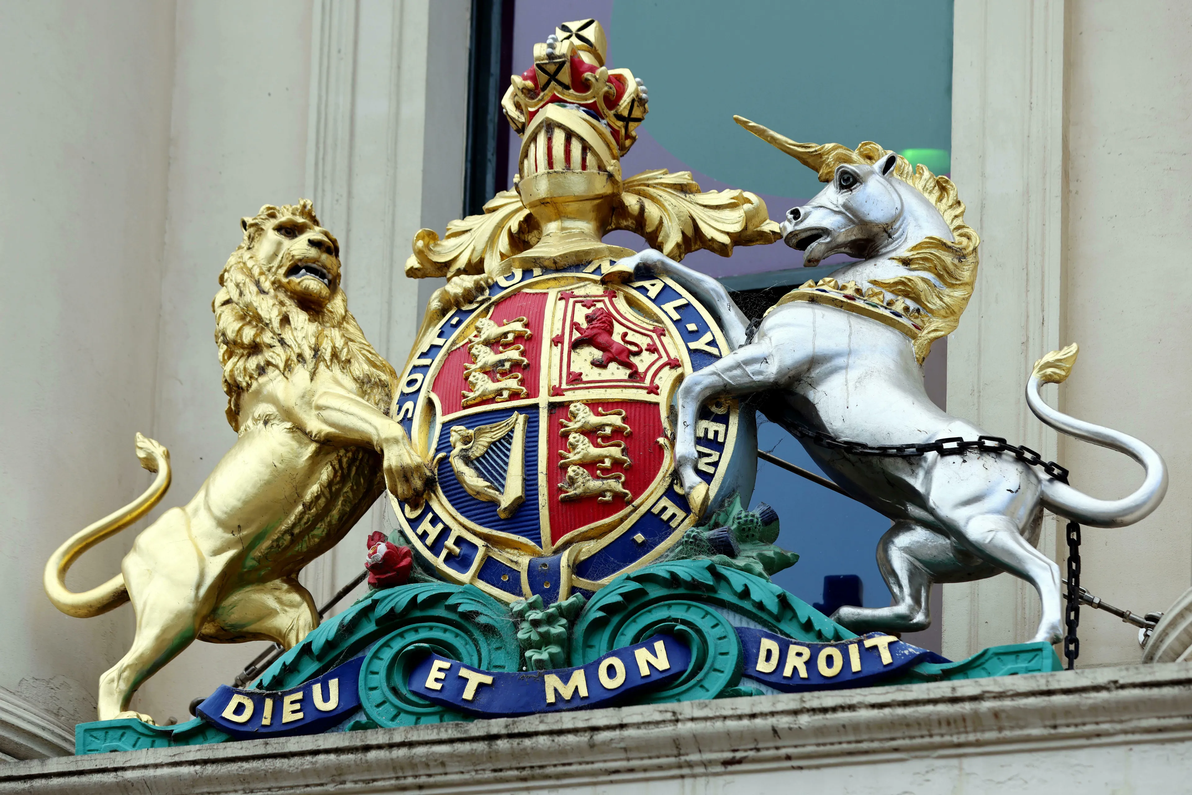 A golden lion and silver unicorn flank a coat of arms, ideal for a General Knowledge Quiz on heraldry.
