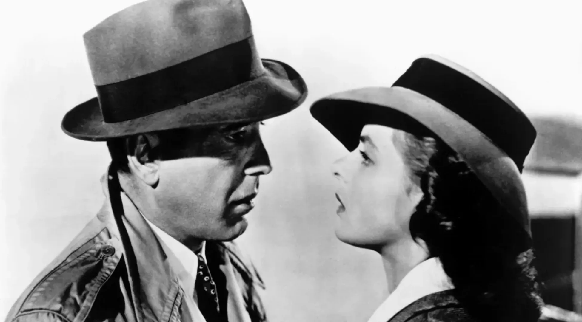 A black and white image of Humphrey Bogart and Ingrid Bergman in fedora hats looking at each other, from the movie Casablanca. General Knowledge Quiz awaits!