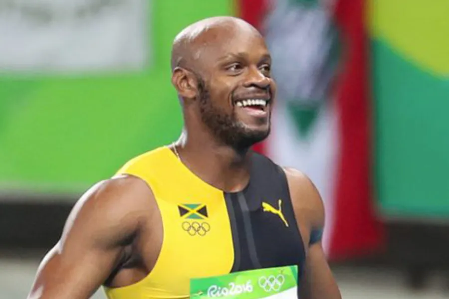 Asafa Powell smiling, wearing a Jamaican track uniform. Fastest man in the world.