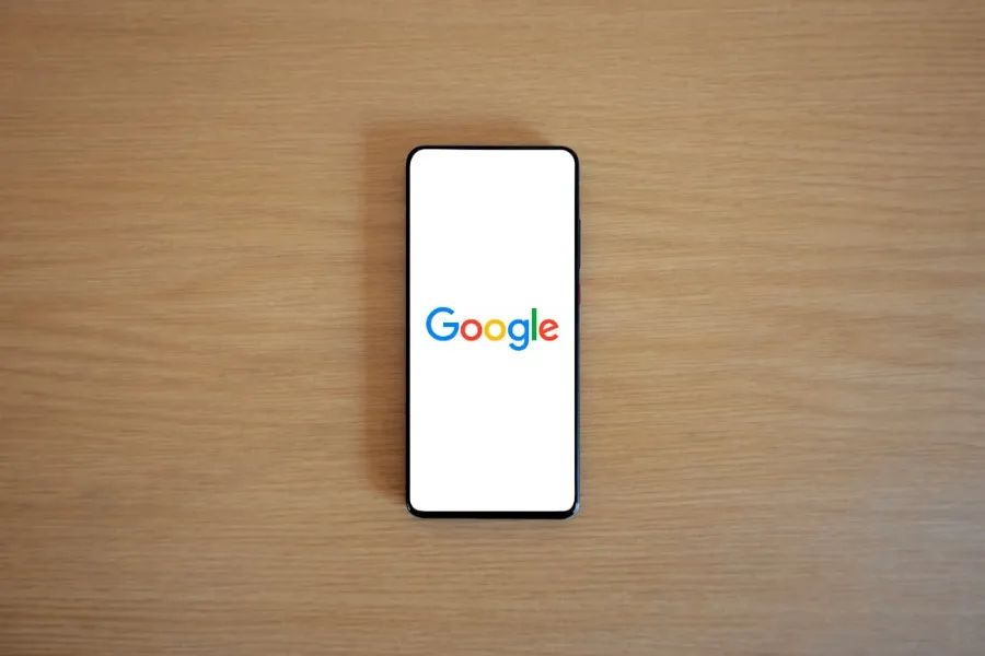Smartphone showing Google logo on a wood background