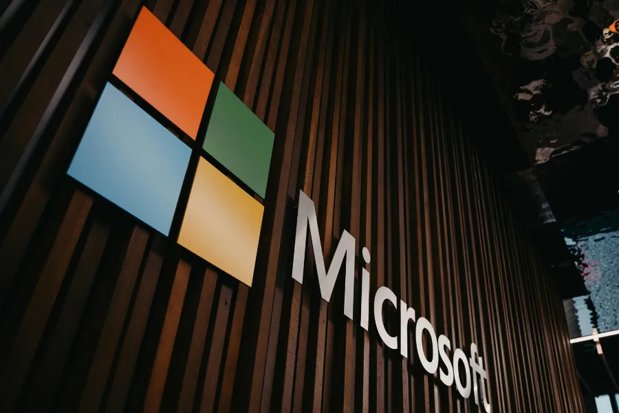 Microsoft logo and name on a wooden slatted wall, showcasing the iconic colorful squares.