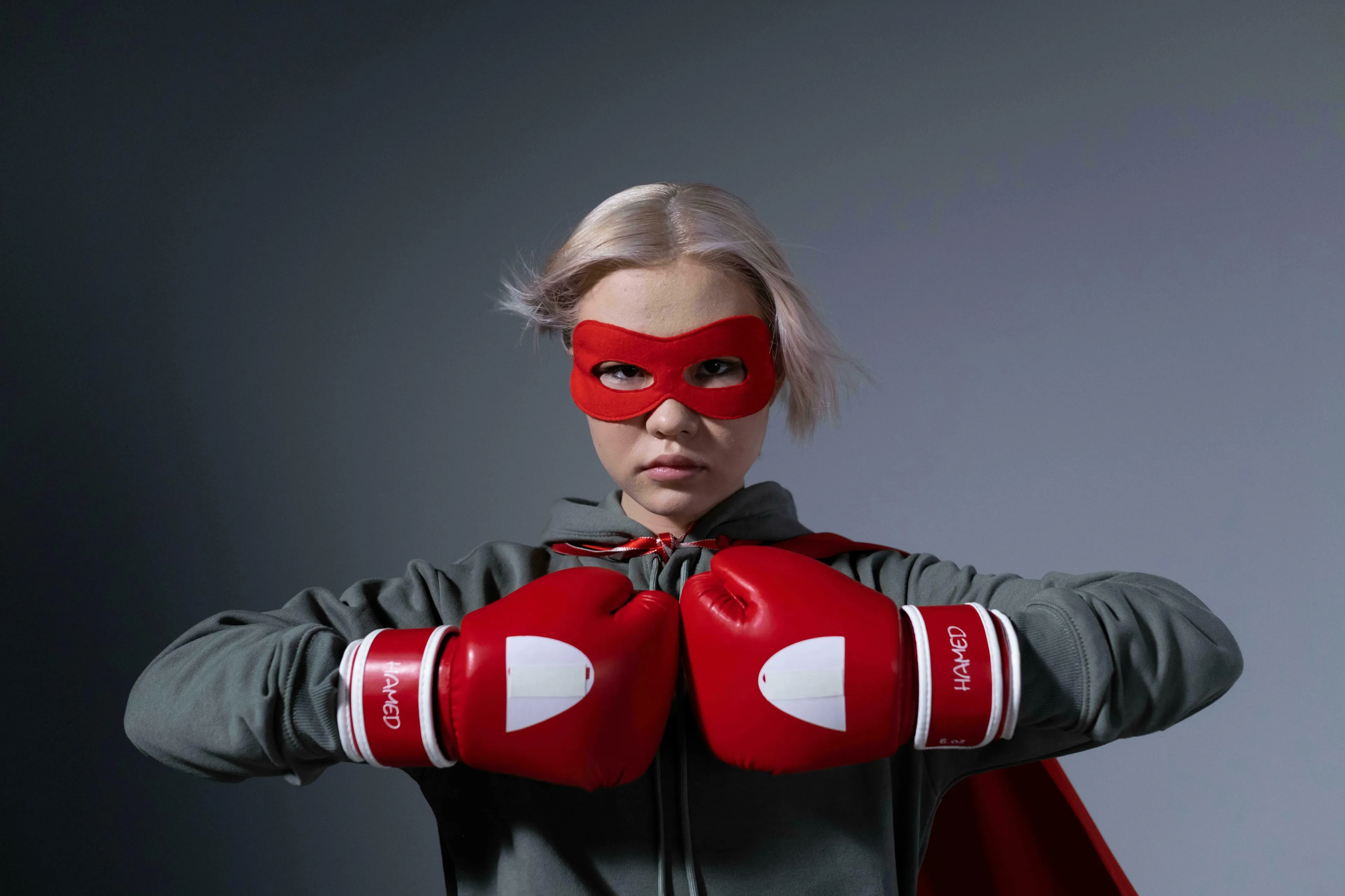 A young person in a superhero mask and boxing gloves, ready to solve your problems and tackle procrastination.