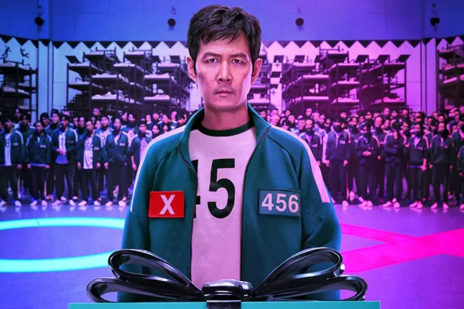 The main character from the TV show Squid Game, looking seriously at the viewer while wearing his numbered uniform.